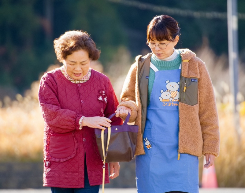 高齢の女性と女性看護師が歩いている様子